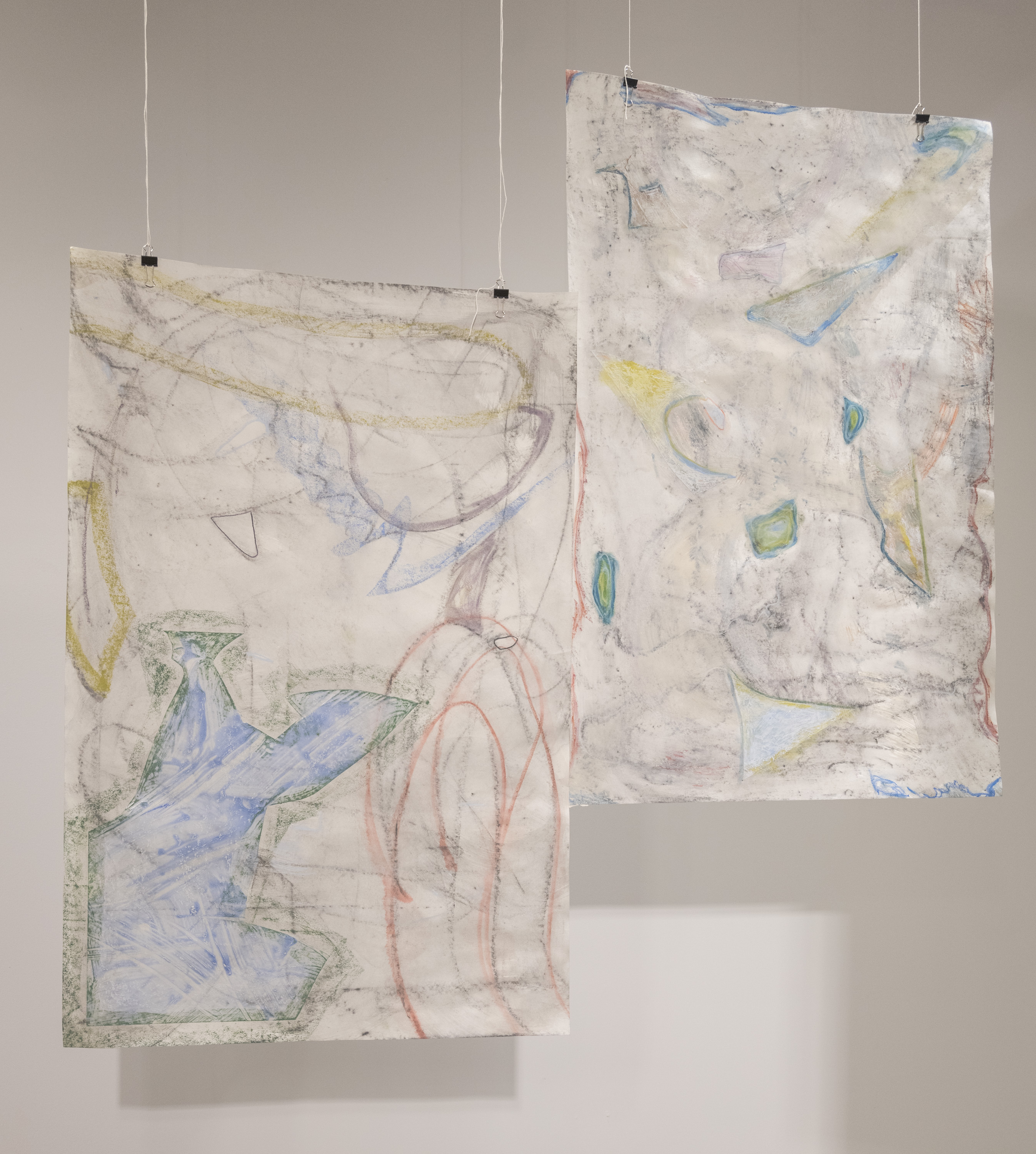 Two sheets of paper are suspended from the ceiling. Both compositions have graphitel backgrounds. Debris, on the left, focuses more on broad strokes, and remnants, on the right, focuses more on pulling out smaller negative shapes created by the graphite. Various leftover pieces of mylar are collaged on top.
