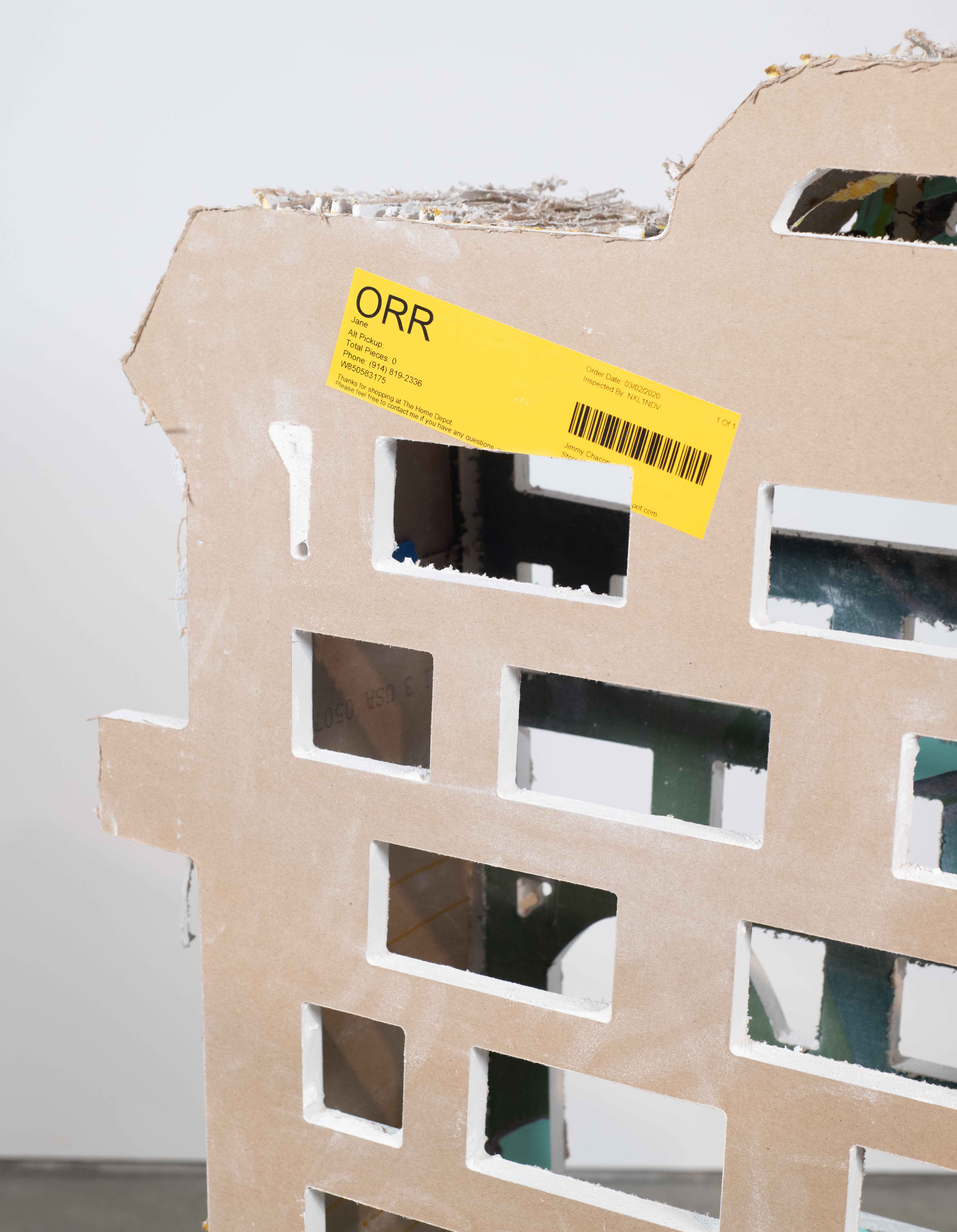 An outline of a trashcan created by to pieces of drywall with a 9” perforated piece of
drywall in-between. The inside of the trashcan can been seen through holes cut through the
drywall. There are painting on the side of the form.