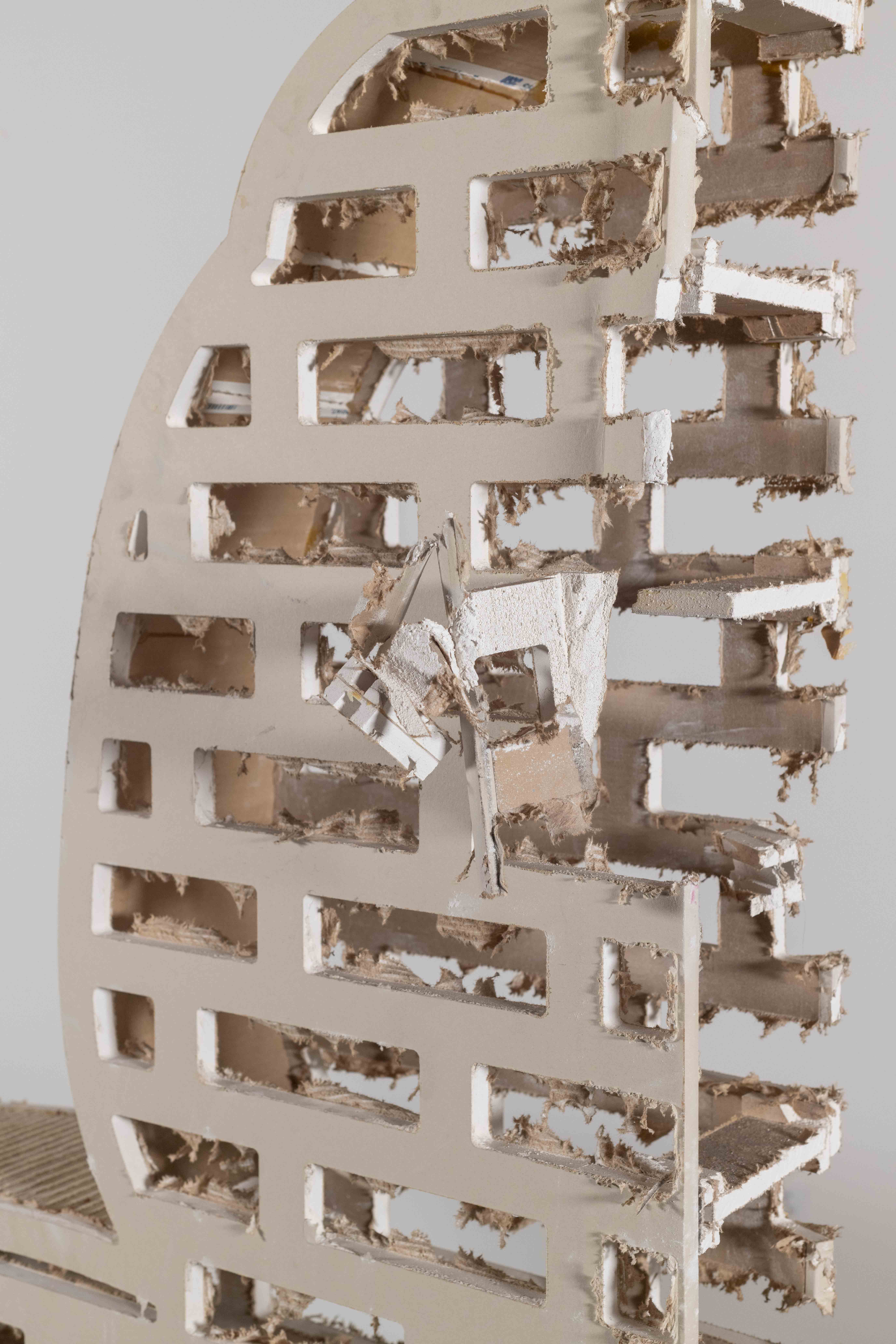 Drywall cut in the shape of the silhouette of a trojan Horse. The head, piece of the
tail, and legs have been removed, A brick pattern is cut into the interior of the horse. You can
look at the stratification that builds the form. From the paper on the outside of the drywall, to
the interior gypsum and brown paper oN the back of the substrate.